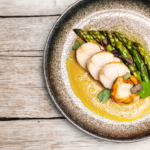 Monkfish tail with asparagus in beurre blanc sauce, a delicious seafood dish.